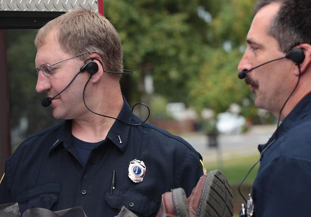 Two team members using lightweight communication headsets outdoors